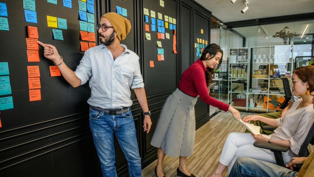 Equipo de trabajo en una sesión de gestión de proyectos e innovación empresarial organizando un portafolio estratégico mediante notas adhesivas en un entorno corporativo.