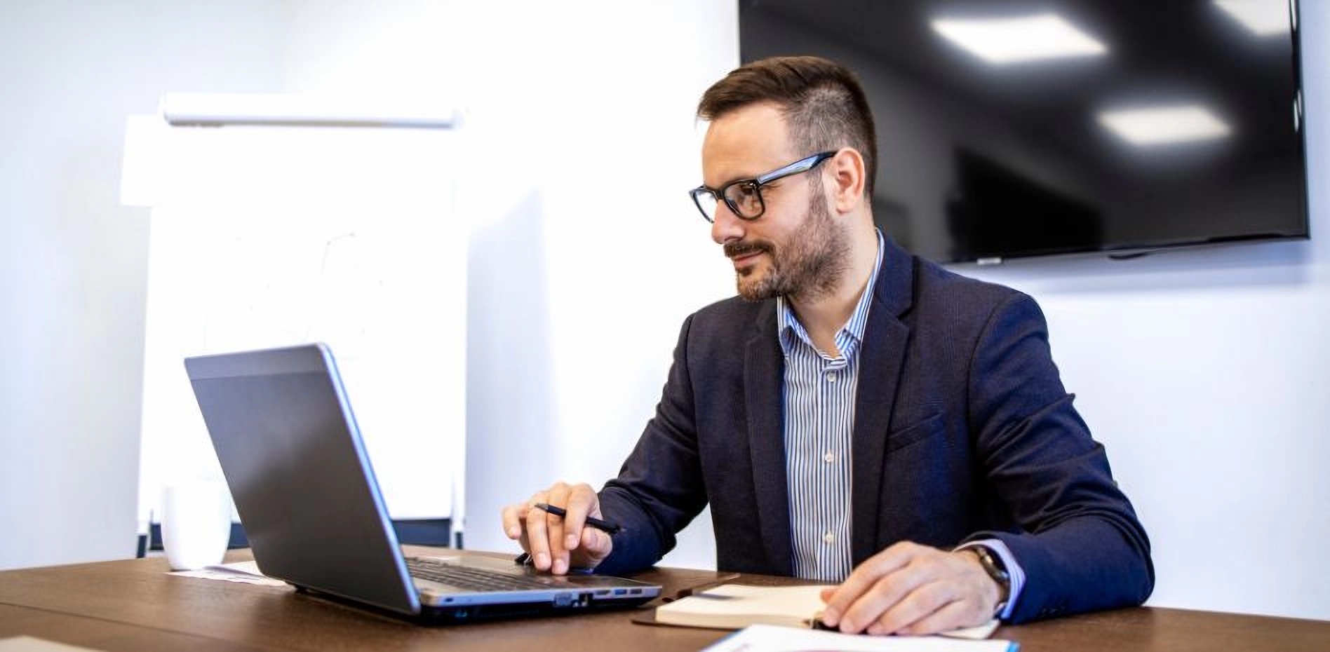 analisis-portafolio-estrategico-innovacion-empresarial-gestion-proyectos Ejecutivo analizando un portafolio estratégico en su laptop para optimizar la gestión de proyectos e innovación empresarial desde una oficina corporativa.