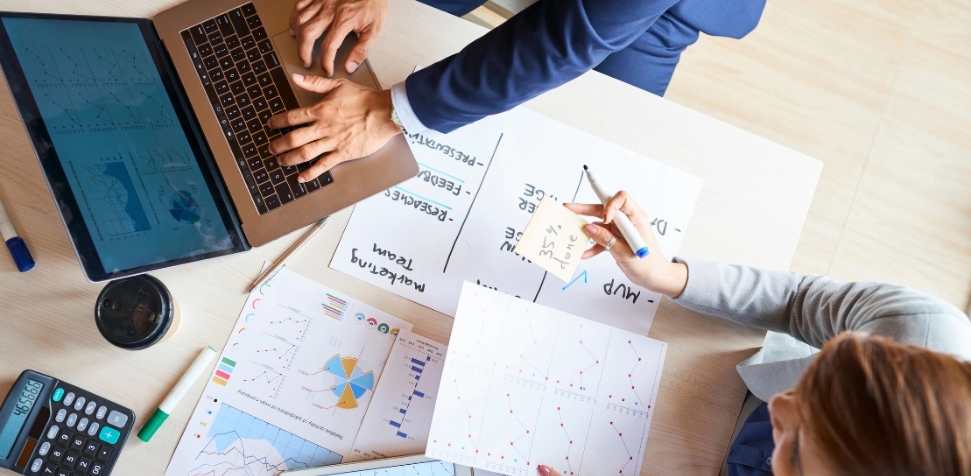 analisis-metricas-gestion-proyectos-innovacion-empresarial-portafolio Vista superior de ejecutivos analizando datos financieros y métricas de avance para la gestión de proyectos e innovación empresarial dentro de un portafolio estratégico.