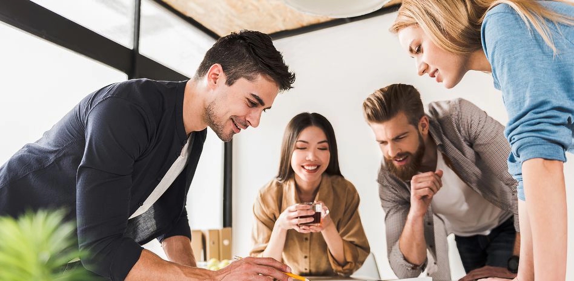 Grupo de profesionales colaborando activamente alrededor de una mesa de trabajo, diseñando estrategias conjuntas para la gestión de proyectos y la innovación empresarial dentro de un portafolio estratégico.