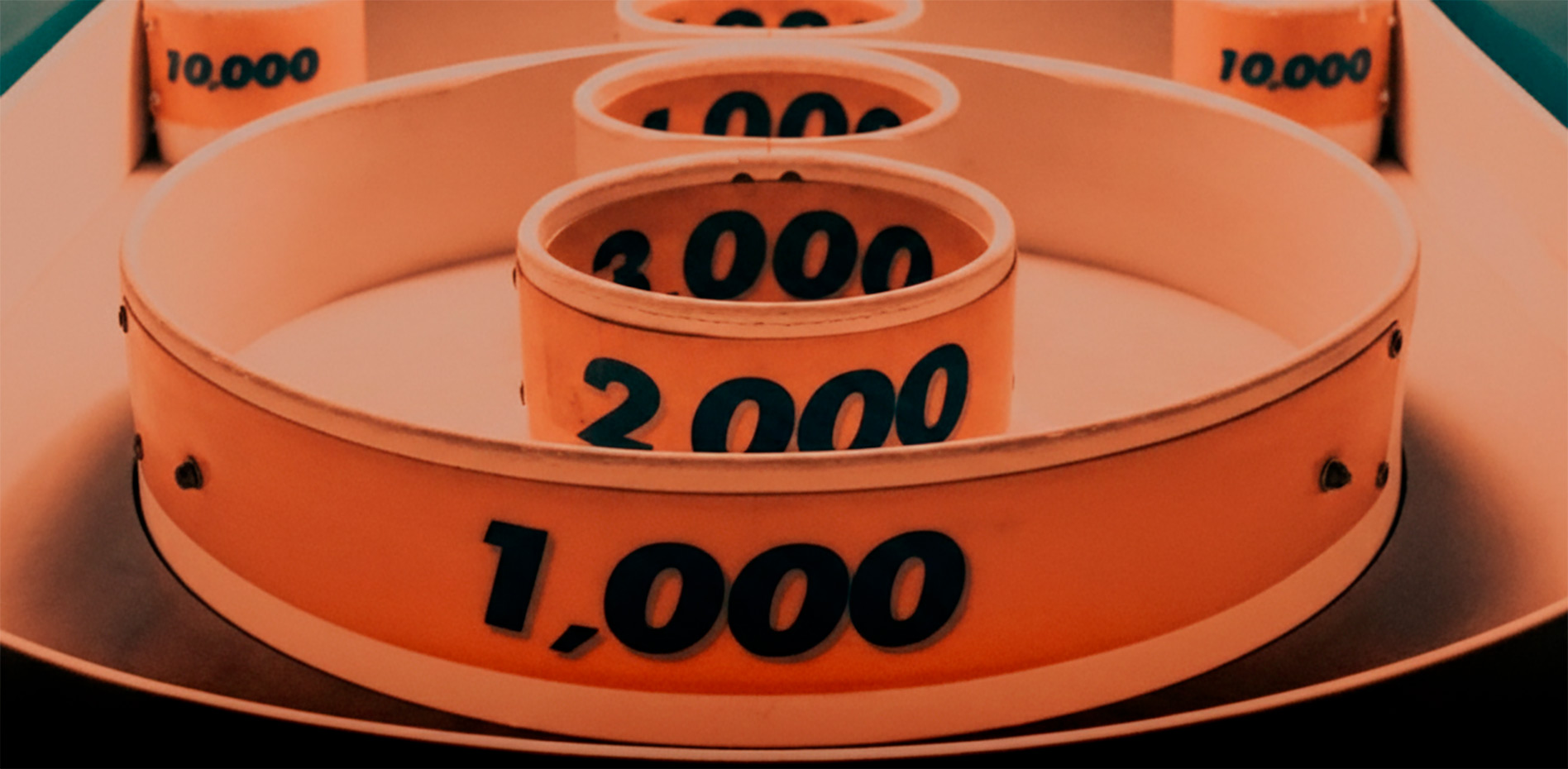 objetivos-puntuacion-gamificacion-estrategia-innk Primer plano de un juego de puntería con anillos concéntricos que muestran puntuaciones de 1,000, 2,000 y 3,000, representando la consecución de objetivos y metas.